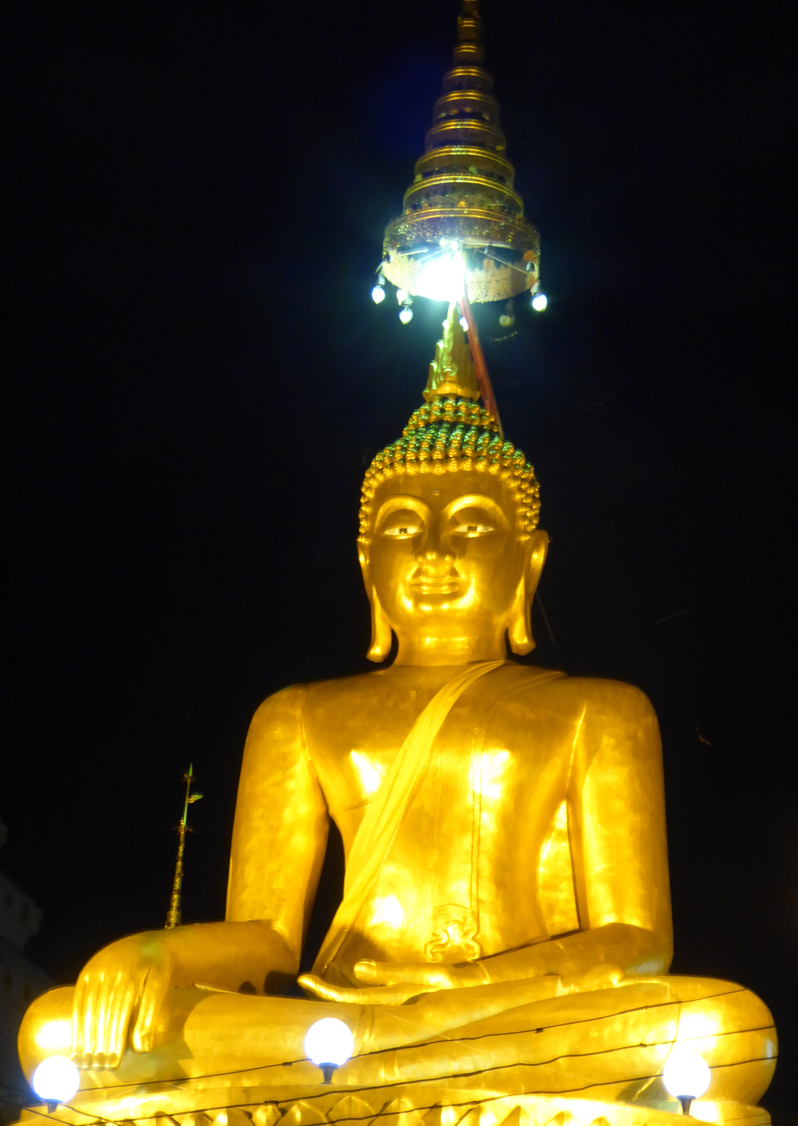 a golden Buddha statue at night